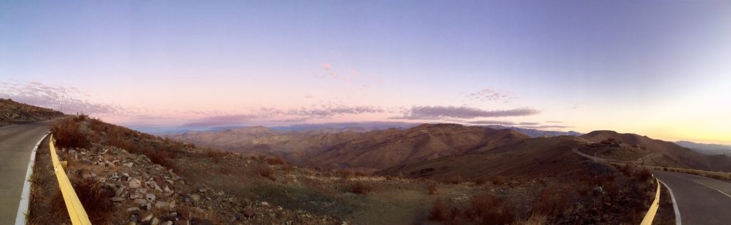 A panorama of the Chilean desert at sunset with scattered purple clouds