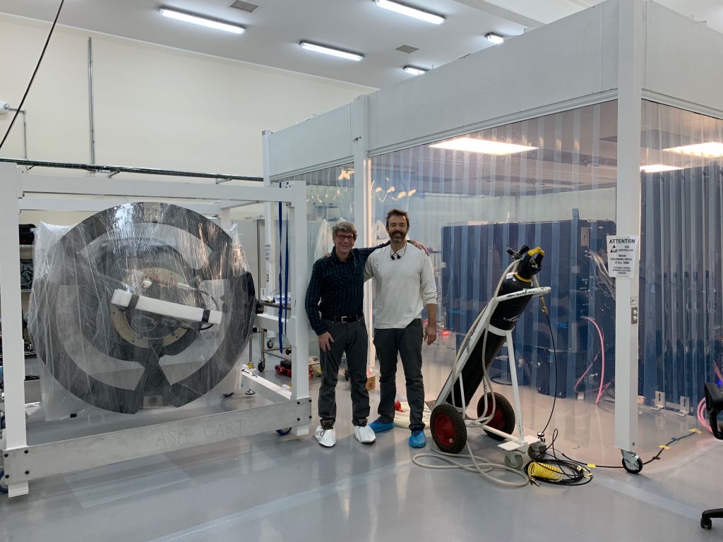 Jared Males and Laird Close, MagAO-X and MagAO PIs, stand next to their respective instruments in the LCO cleanroom