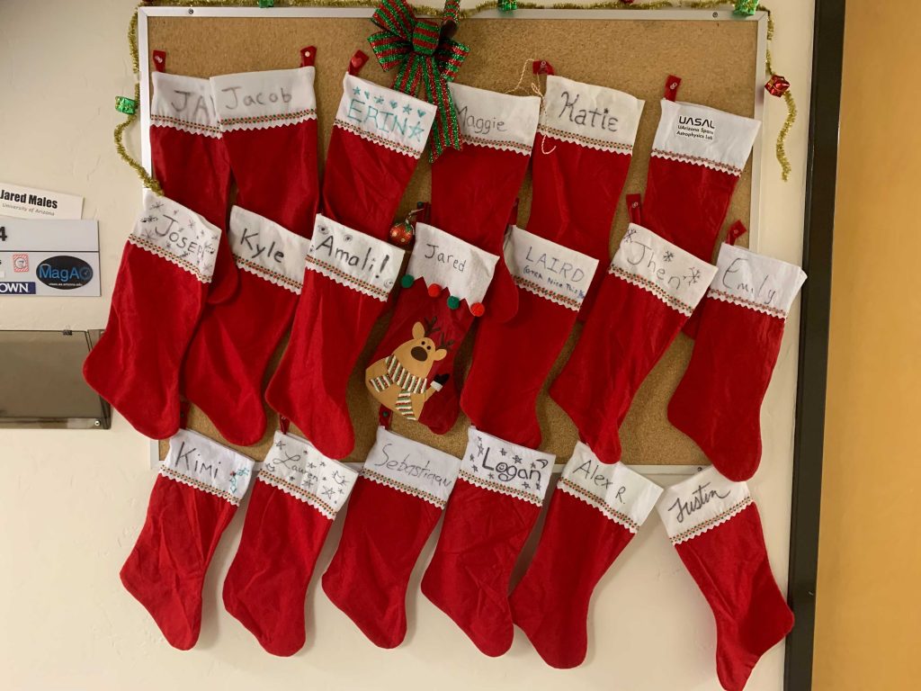 Picture of christmas stockings hanging from the bulletin board in the hall outside Jared's office