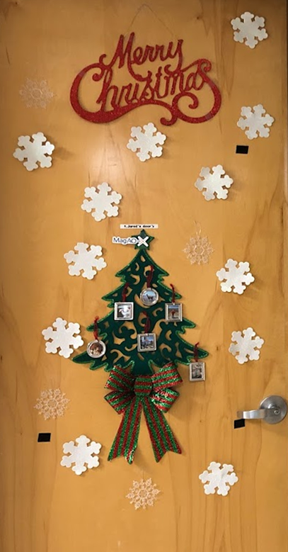 Christmas decorations on Jared's office door, including a cutout of a tree with multiple miniature framed pictures as ornaments.