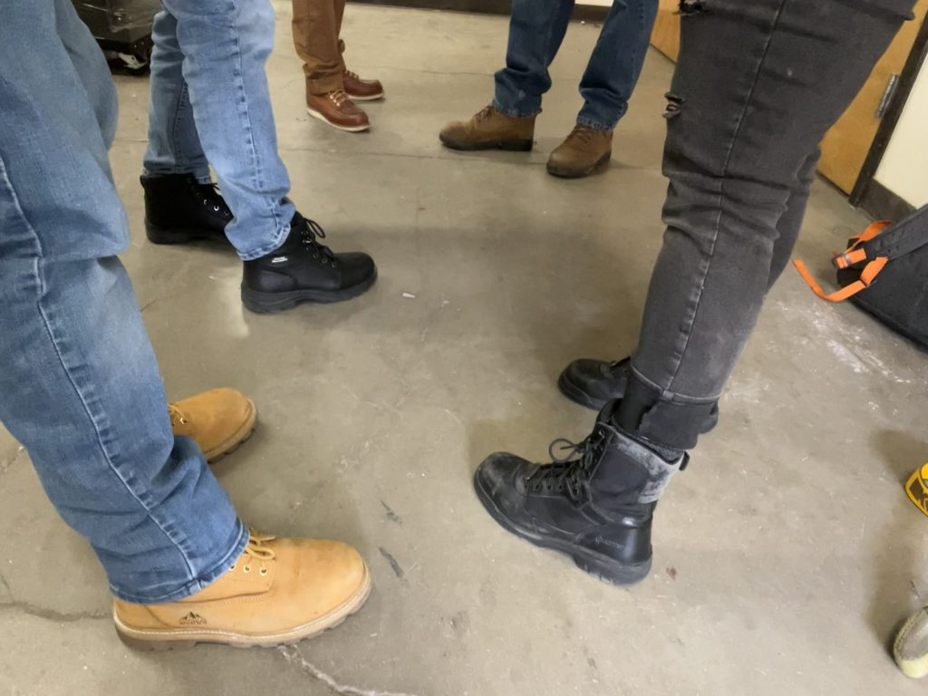 five pairs of steel toe boots on grad students